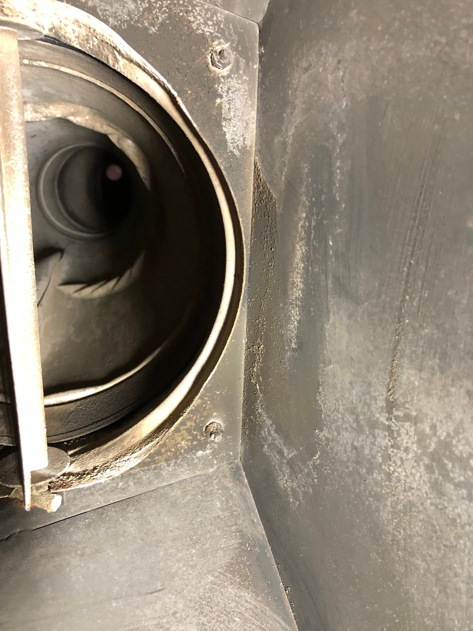 Interior of Factory chimney serving a factory fireplace is warped and damaged by heat. May have been caused by overfiring or due to a chimney fire.